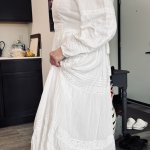 Woman in white LDS temple dress standing outdoors with soft natural light and greenery in the background