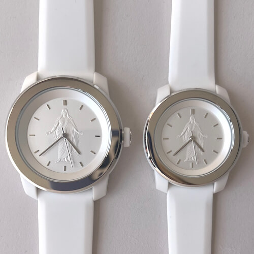 Close-up of silver Christus wristwatch with white face and image of the Christus statue at center